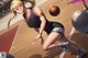 A woman in a cheerleading uniform dribbling a basketball on a court.