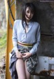 A woman in a blue shirt and plaid skirt posing for a picture.