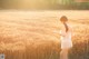 A woman in a white dress standing in a field.