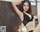 A woman in a black lingerie leaning against a wall.