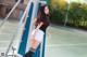 A woman in a black shirt and white shorts posing on a basketball court.