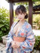 A woman in a blue kimono posing for the camera.