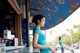 A woman standing at a counter in front of a store.